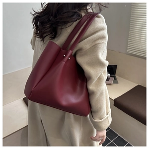 Detail view of burgundy leather tote bag with metallic studs and large capacity