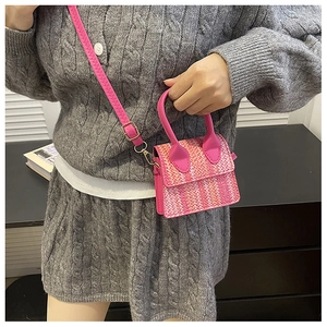 Close-up of pink tweed mini bag with leather top handle and gold-tone metal hardware