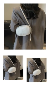 Detail of silver metallic textured pillow bag with delicate water drop pendant