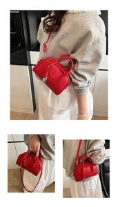 Detail of red pebbled leather handbag featuring elegant knot design and silver hardware charms