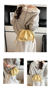 Detailansicht der gelben Falten-Cloud-Tasche mit Metallkette und Logo-Branding