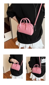 Close-up of pink litchi grain leather mini Boston bag with silver ball ornament