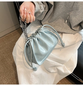 Detailansicht der hellblauen Glanzledertasche mit silberner Gliederkette am Griff