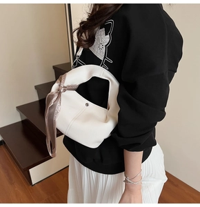 Détail du sac à main en cuir litchi blanc avec foulard en soie décoratif sur l'anse