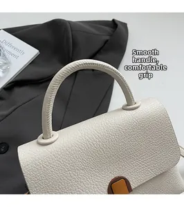Détail d'un sac à main blanc avec poignée arrondie et boucle vintage dorée chic