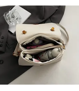 Structure interne du sac en cuir beige montrant les doubles compartiments et le rangement