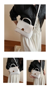 Détail du sac à main en cuir blanc à motif litchi avec fermoir en métal doré élégant