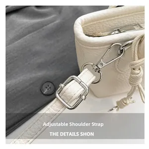 Close-up of white lychee leather handbag with adjustable strap and silver metal hardware