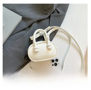 Detailed view of white mini leather handbag with phone for size comparison context