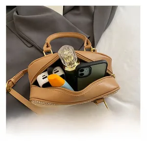 Detail showing internal capacity of straw woven boston bag with leather contrast panels