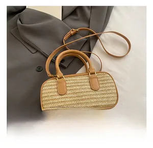 Detail of woven straw texture and premium brown leather straps on a boston bag