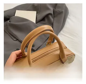 Detail of straw woven bag with brown leather handles and dual zipper closure system