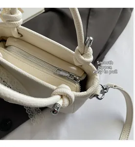 Détail d'un sac à main blanc crème en cuir grainé avec fermeture éclair en métal lisse