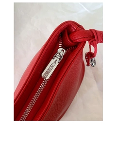 Détail d'un sac à main en cuir grainé rouge avec fermeture éclair en métal argenté
