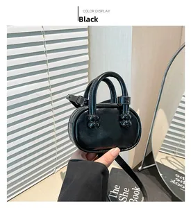 Detailed view of the black mini square bag with glossy leather and beaded fastener