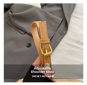 Macro detail of adjustable brown leather shoulder strap with golden metal buckle for woven bag