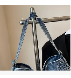 Close-up of durable denim tote bag strap with reinforced stitching and metal buckle
