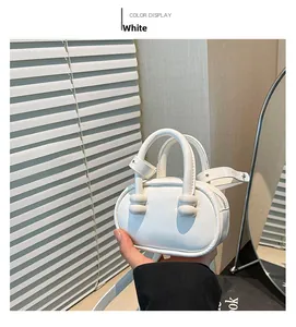 Detailed view of a white mini handbag with spherical handle accents and an adjustable strap