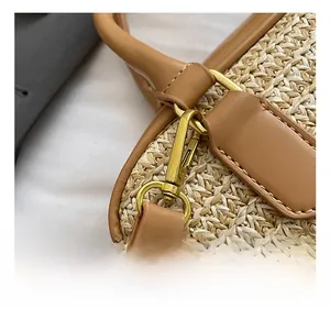 Detailed close-up of woven straw texture with tan leather handle and gold hardware hook