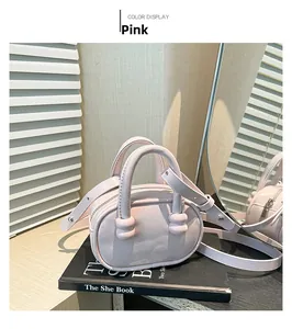Detail of light pink matte leather crossbody bag styled on a book with soft lighting