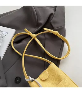 Close-up of yellow lychee texture leather shoulder bag with a slim matching strap