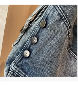 Detail of blue washed denim fabric with metallic buttons and vintage ring texture