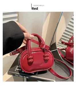 Glossy red pebble-shaped mini crossbody bag with round handle and adjustable strap