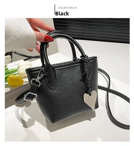 Detail view of black litchi grain square bag with silver heart charm and tulip decor