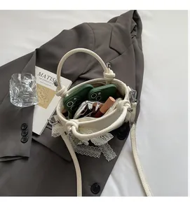 Vue intérieure du sac seau blanc cassé montrant la capacité pour téléphones et maquillage