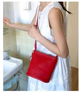 Vue détaillée du sac seau en cuir rouge avec grain fin et finitions élégantes
