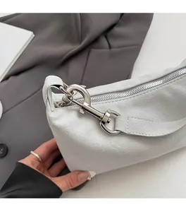 Detailed macro of suede texture shoulder bag with silver hardware and lobster clasp closure