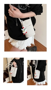 Detailed view of white lychee leather mobile phone bag with a cute white duck pendant