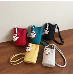 Close-up showing five colors of soft leather mini bucket bags with cute duck pendants