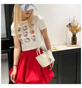 Detailed view of a white lychee grain shoulder bag with a cute heart pendant accessory