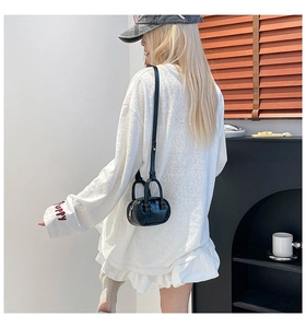 Detail van PUPPY-borduurwerk op witte jurk met zwarte mini bowlingtas voor dames