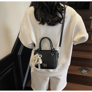Sac seau noir motif litchi avec nœud en dentelle perlée et bandoulière amovible