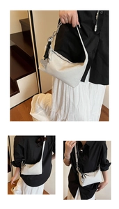 Detail of white large crossbody bag with heart pendant and metal chain strap