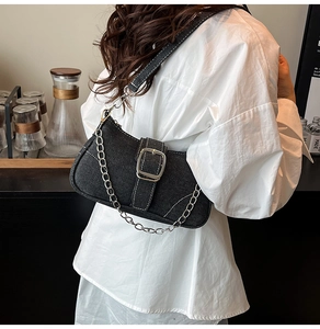 Detail of black denim shoulder bag with silver chunky chain and adjustable buckle strap