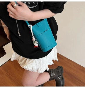Crossbody phone bag in litchi grain leather with cute duck pendant on model
