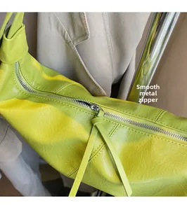 Close-up of lime green lychee leather bag with silver metal zippers and smooth pulls