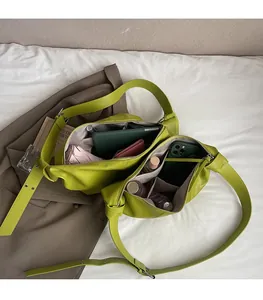 Top view of spacious interior compartments in a green shoulder bag for daily essentials