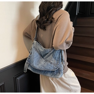 Detail of deconstructed denim tote bag with jacket pocket design shown on model shoulder