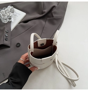 Detail view of white lychee pattern crossbody bag showing magnetic closure and interior