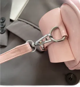 Detail of premium silver metal buckle on a pink leather Boston bag with neat stitching