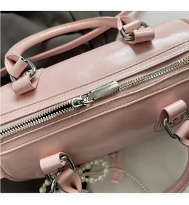 Close-up of the smooth silver zipper and leather texture of the pink Boston handbag