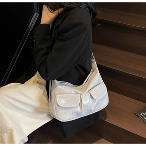Detail of white leather hobo bag featuring double front flap pockets and wide strap