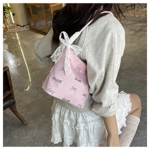 Vista dettagliata della borsa rosa con fiocco in pizzo bianco e stampa decorativa