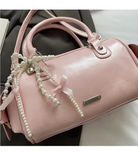 Detail of soft pink Boston bag with large pearl bow and smooth vegan leather finish