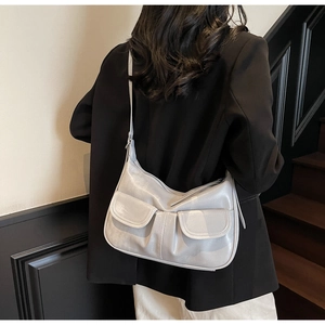 Silver PU leather shoulder bag with double pockets shown on a model in a minimal setting
