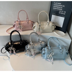 Five glossy mini bowling bags in pastel colors with beaded bow charms and shoulder straps